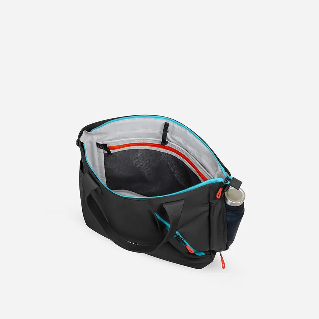 A top-down view of the Sherpani Jetsetter Tote in Chromatic showing its interior and a water bottle attached to the side against a white background.