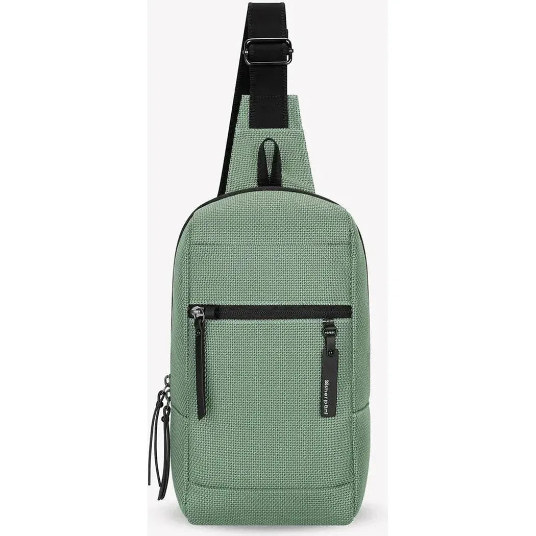 A front view of the Sherpani Metro AT in Aloe Mist showing the front zip pocket and adjustable shoulder strap against a white background.