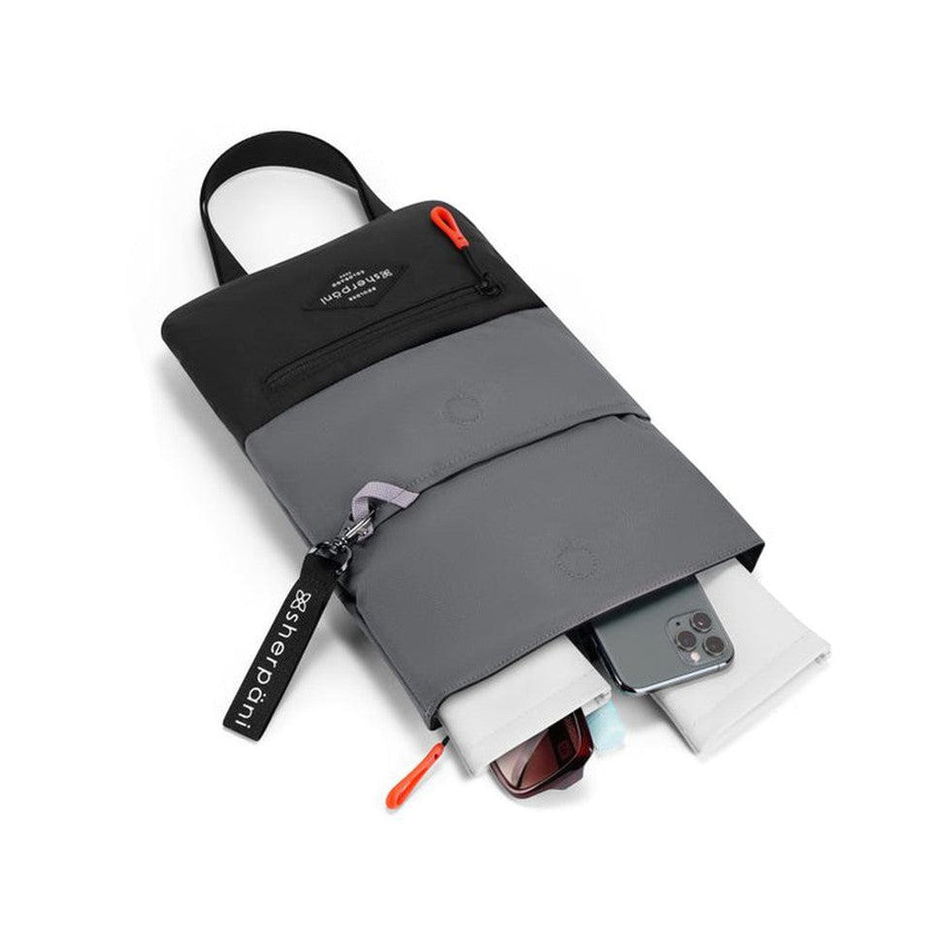 A top-down view of the Sherpani Pica Raven bag showing its front pocket and a smartphone inside, against a white background.