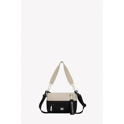 A front view of the Sherpani Skye bag in Alchemy color with a beige shoulder strap and black bottom section, showing a small logo and a tag, against a plain white background.