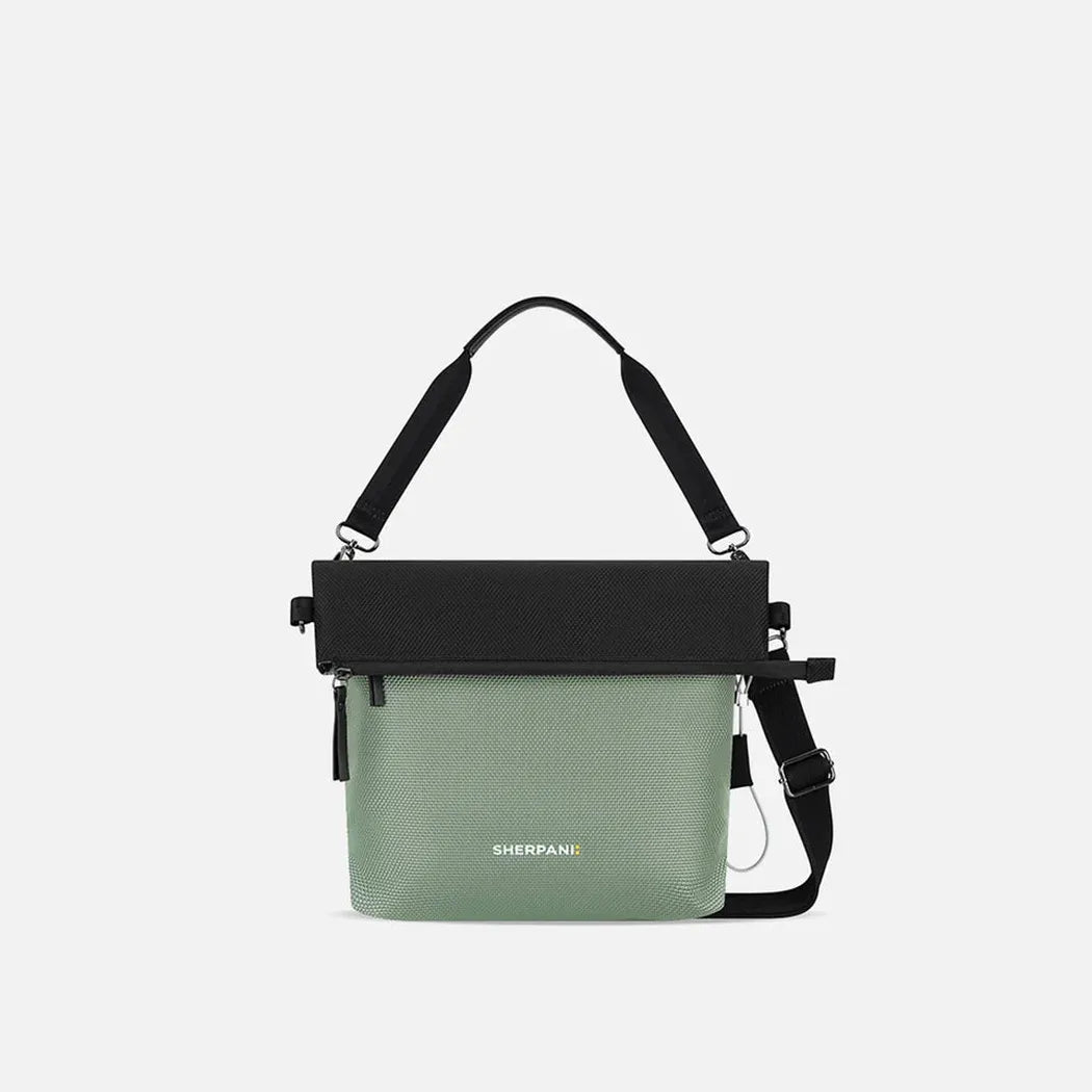 A front view of the Sherpani Vale AT bag in Aloe Mist with a black top flap and adjustable strap against a white background.