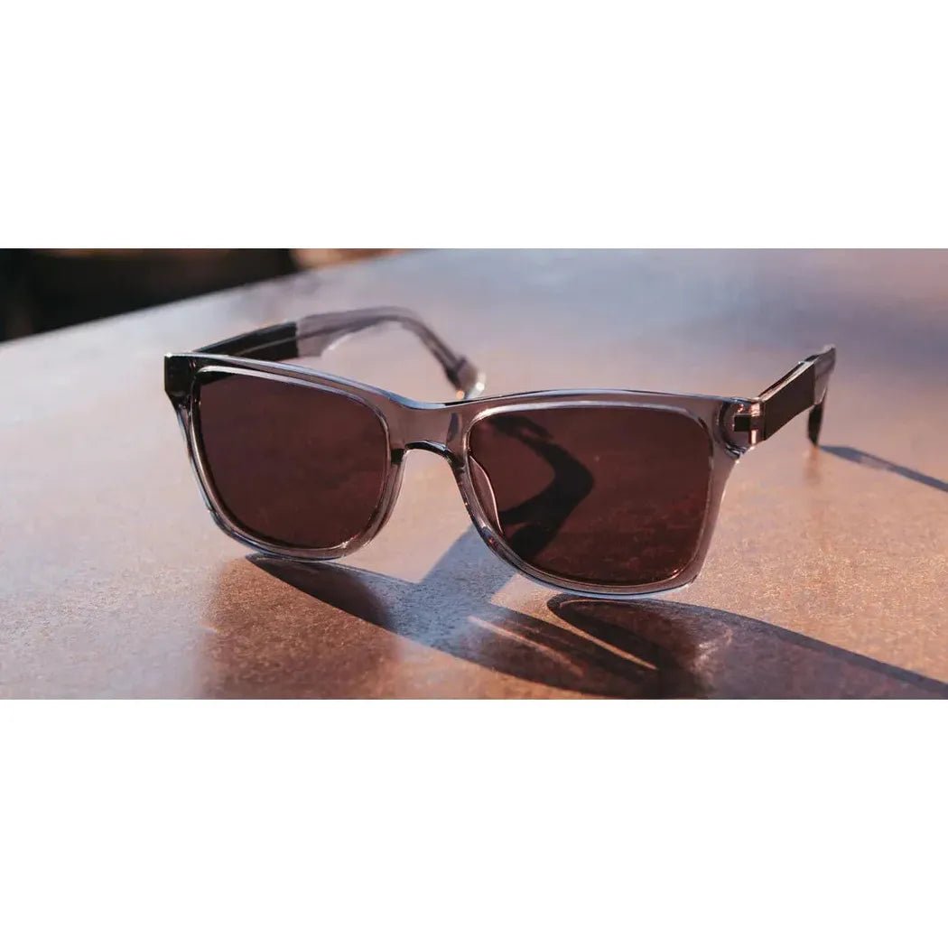 A front view of the Shwood Canby XL sunglasses with dark lenses on a wooden surface.