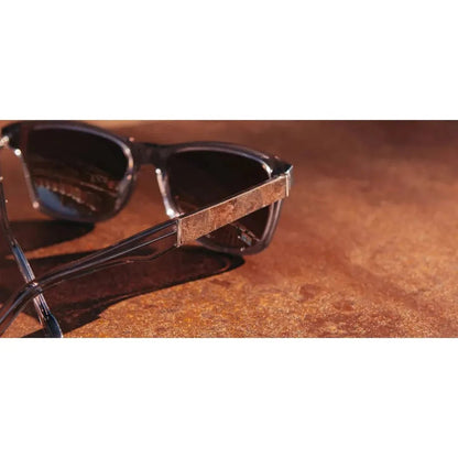 Side view of the Shwood Canby XL Black // Ebony sunglasses showing the textured temple detail on a brown surface.