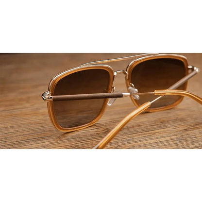 Side view of the Shwood Grant sunglasses with caramel and gold frames and walnut arms on a wooden surface.