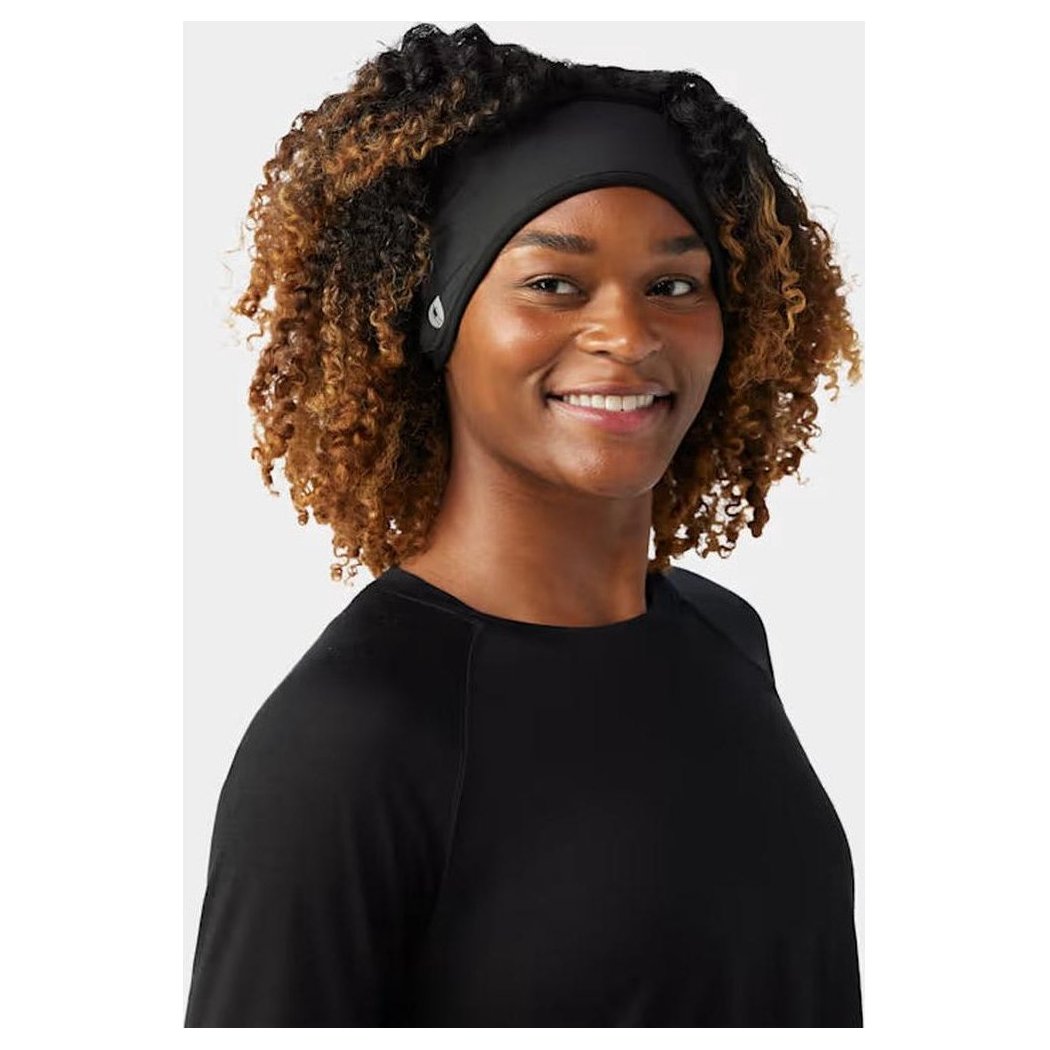 A front view of the Smartwool Active Fleece Wind Headband in Black on a model with curly hair against a plain background.
