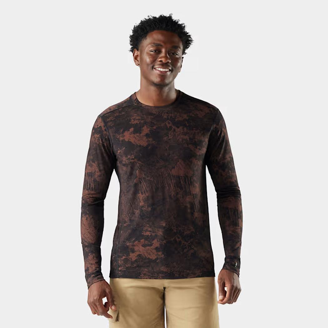 A front view of the Smartwool Men's Classic All-Season Merino Base Layer Long Sleeve in Black on a model wearing khaki shorts against a white background.
