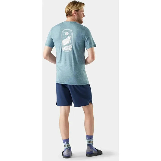 Back view of the Smartwool Men's Merino Hemp Blend Peak Pints Short Sleeve Graphic Tee in Dusty Teal on a model against a white background.