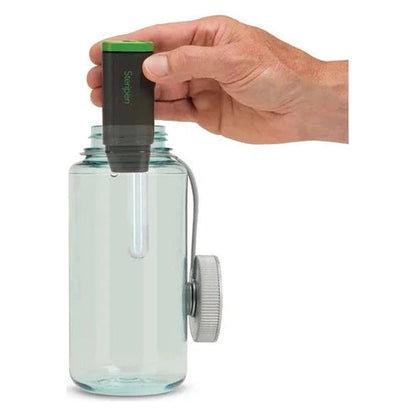 A hand holds the Steripen Adventurer Opti UV Water Purifier over a clear water bottle with a gray cap, shown from a front angle against a white background.