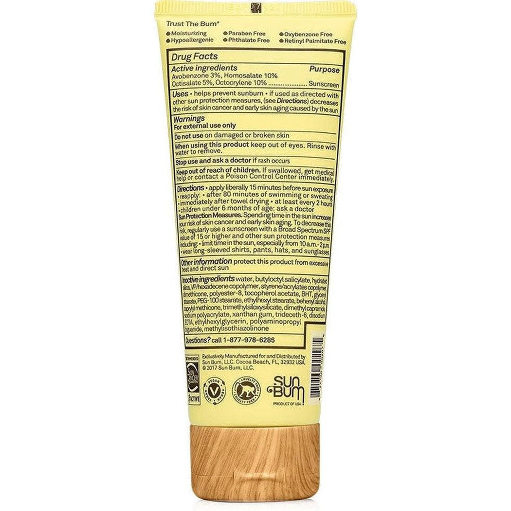 Back view of Sun Bum SPF 50 Clear Face Sunscreen Lotion showing the drug facts label and wooden cap against a white background.