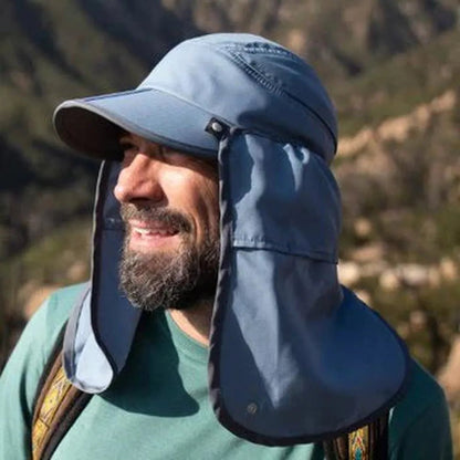 A man wears the Sunday Afternoons Sun Guide Cap in Sandstone, showing the neck flaps and a mountain background.