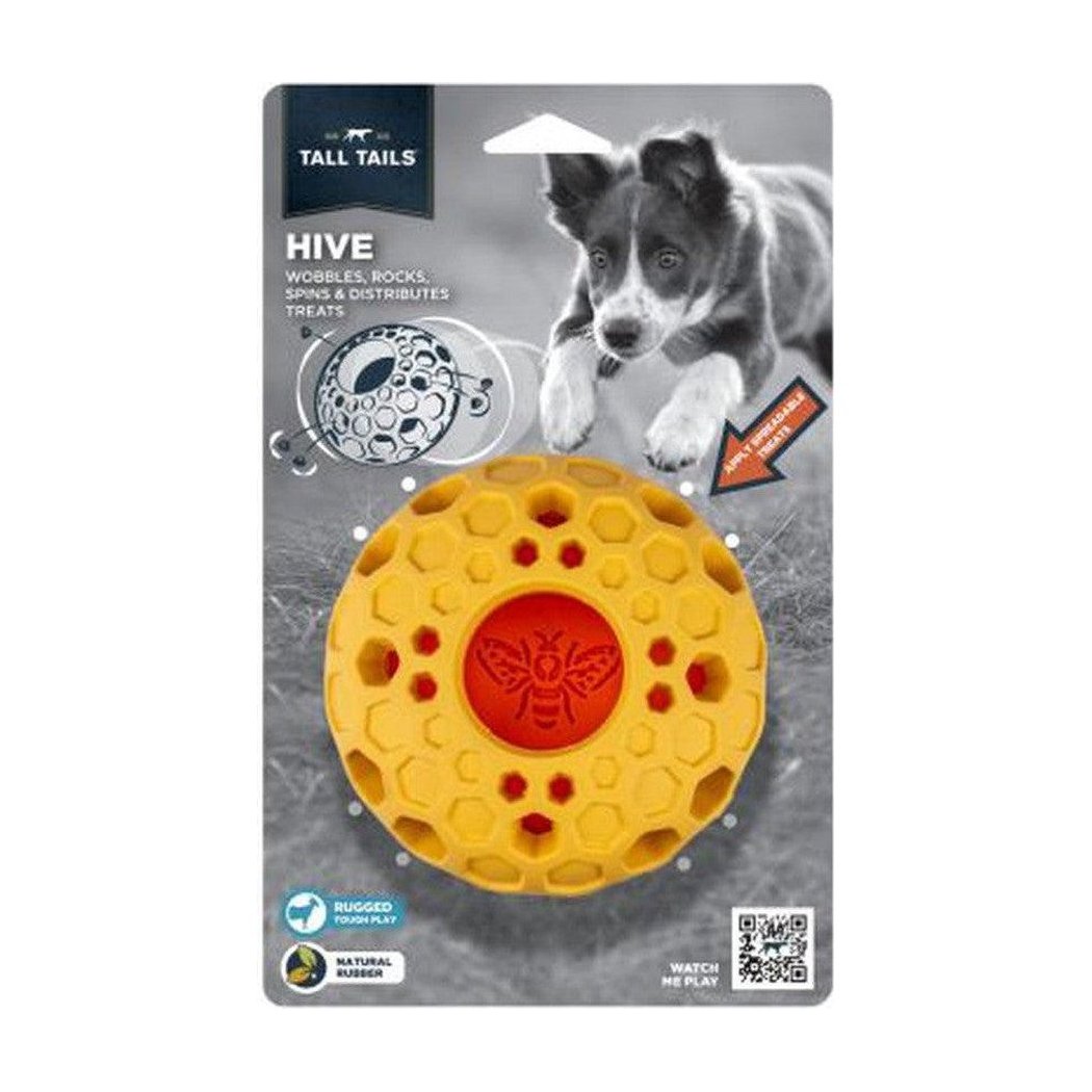 A front view of the Tall Tails Natural Rubber Bee Hive Toy showing the yellow rubber toy with a red bee center against a gray background with a dog image.