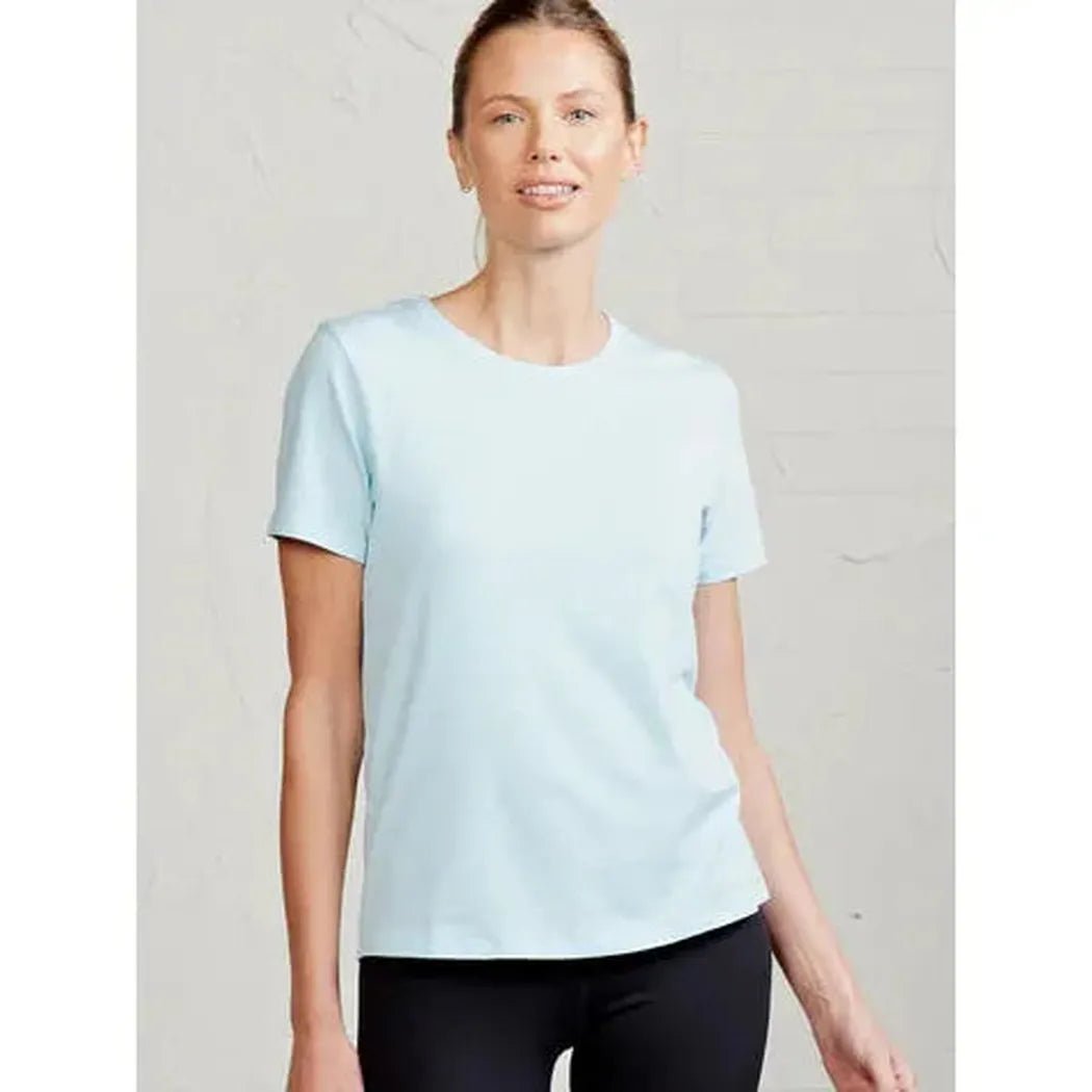 A front view of the Tasc Women's All Day T in Coast color on a model wearing black bottoms against a light gray background.
