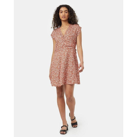 A front view of the Tentree Women's Woven Wrap Dress in Baked Clay Floral on a model wearing black sandals against a white background.