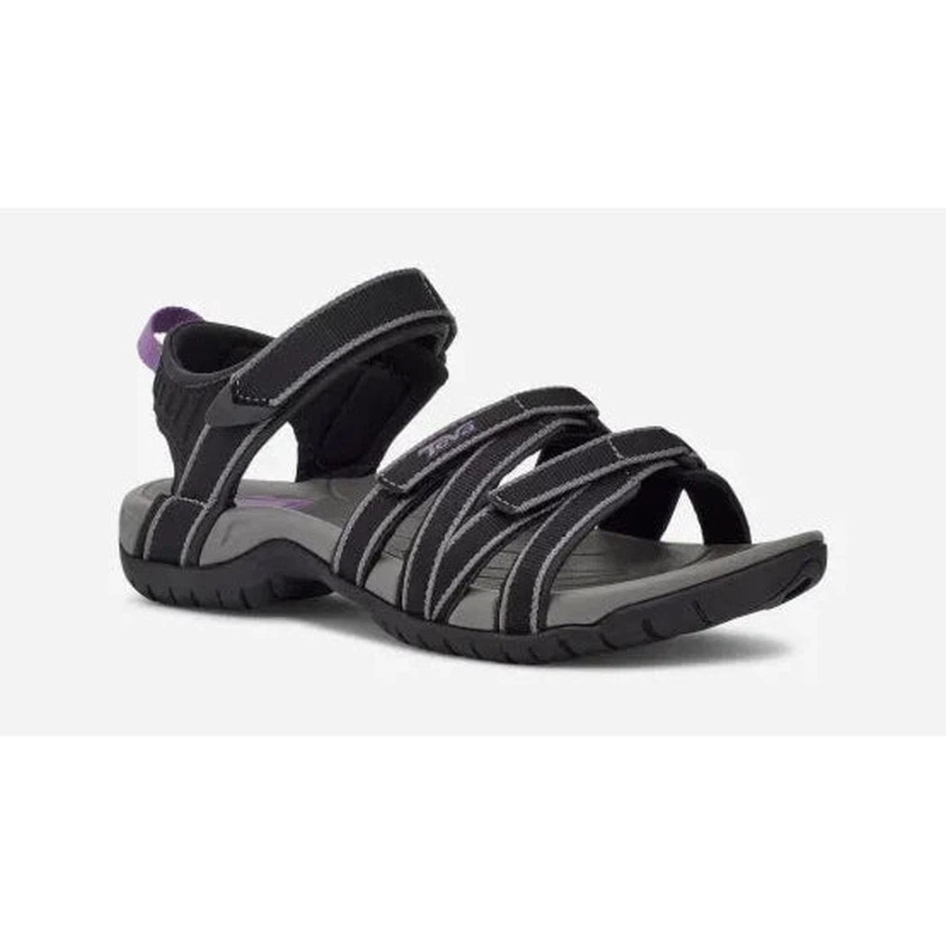 Side view of the Teva Women's Tirra in Black/Grey showing the adjustable straps and white stitching against a white background.