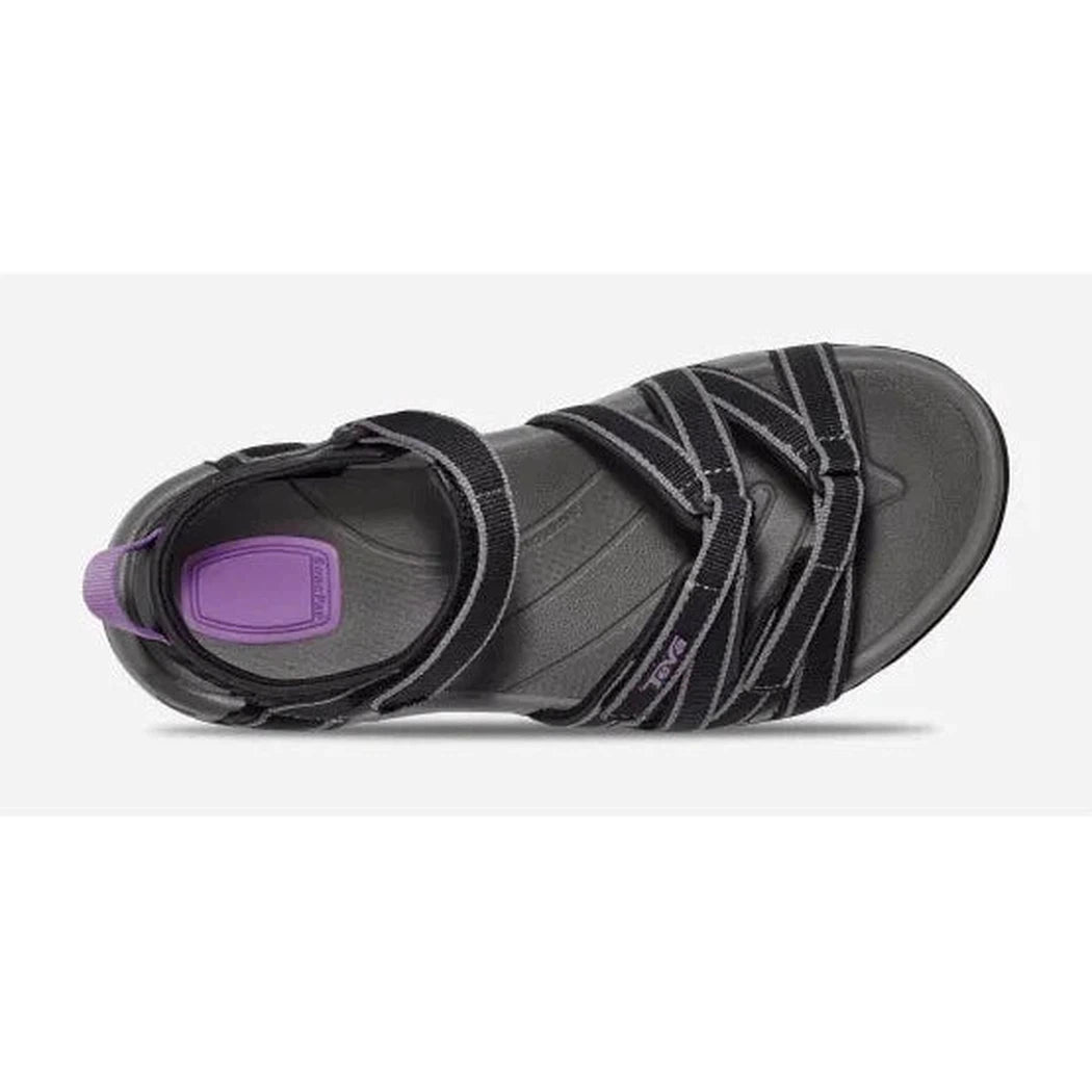 The bottom view of the Teva Women's Tirra in Black/Grey shows the strap details and purple insole against a white background.