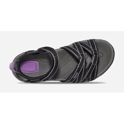 The bottom view of the Teva Women's Tirra in Black/Grey shows the strap details and purple insole against a white background.