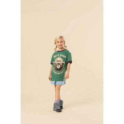 A front view of The Landmark Project Keep It Green Youth Short Sleeve Ringer Tee in Palm Leaf/Dusk on a model against a neutral background.