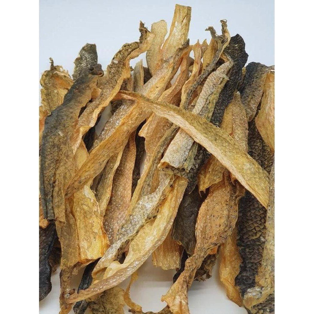 Dried salmon skins from Tickled Pet Salmon Skins 6oz Bag, showing their natural texture and varied brown tones against a plain white background.