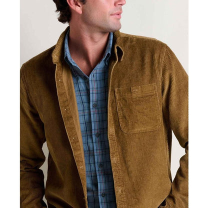 A man wears the Toad & Co Men's Cassadia Long Sleeve Shirt in Honey Brown over a blue plaid shirt, shown from the front with a plain background.