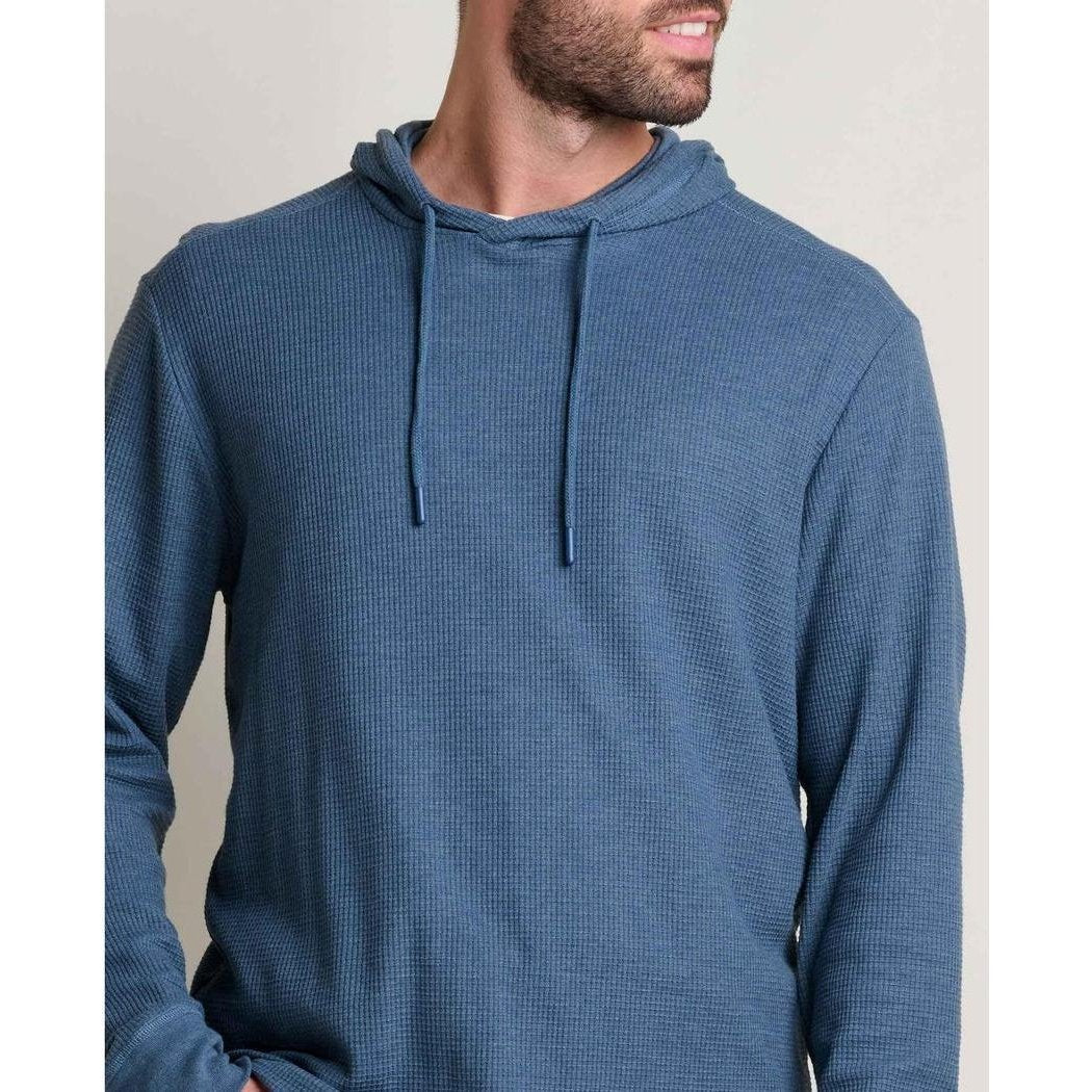 A front view of the Toad & Co Men's Framer II Long Sleeve Hoodie in Pacific Blue on a model with a neutral background.