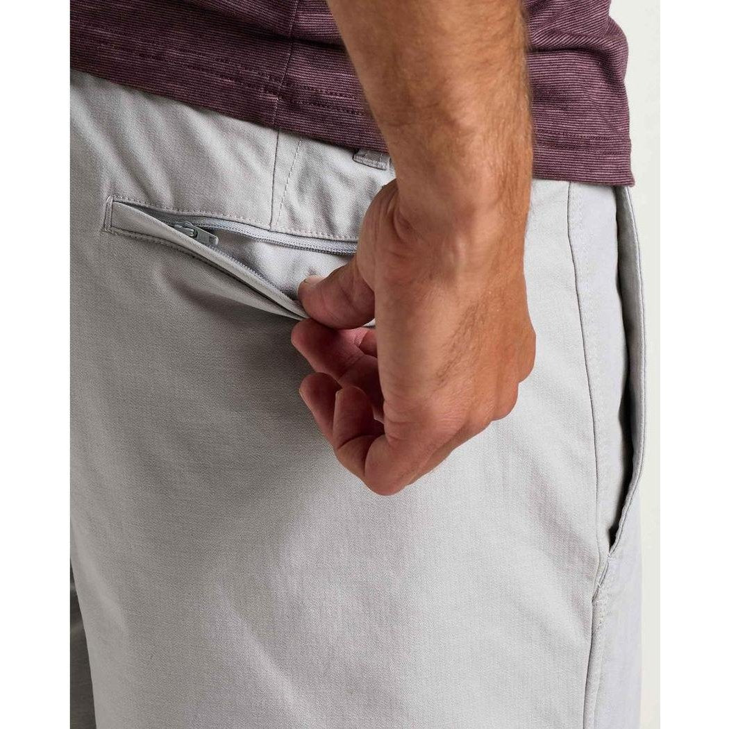 Side view of the Toad & Co Men's Mission Trek Chino Short in Basalt showing the zippered back pocket and model hand.