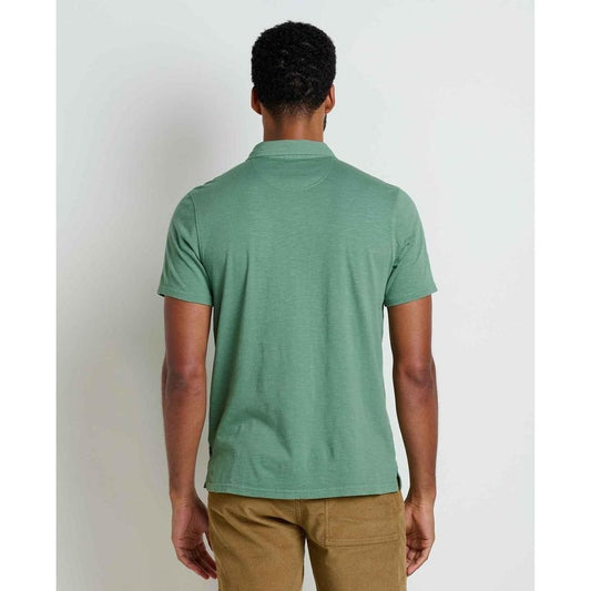 Back view of the Toad & Co Men's Primo Short Sleeve Polo in Ivy on a model wearing khaki pants against a plain white background.