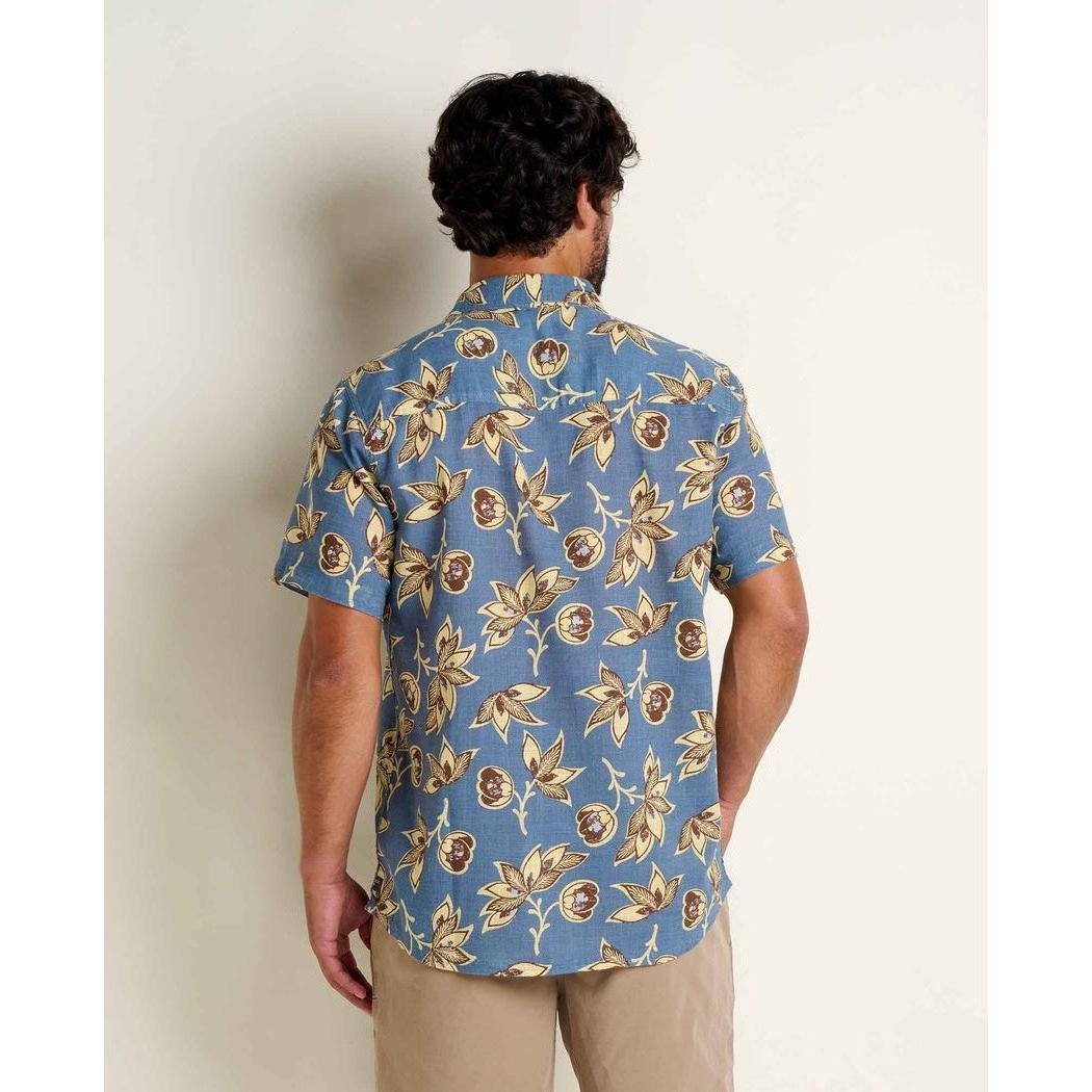 Back view of the Toad & Co Men's Salton Short Sleeve Shirt in Pacific Blue Print on a model wearing khaki pants against a plain wall.