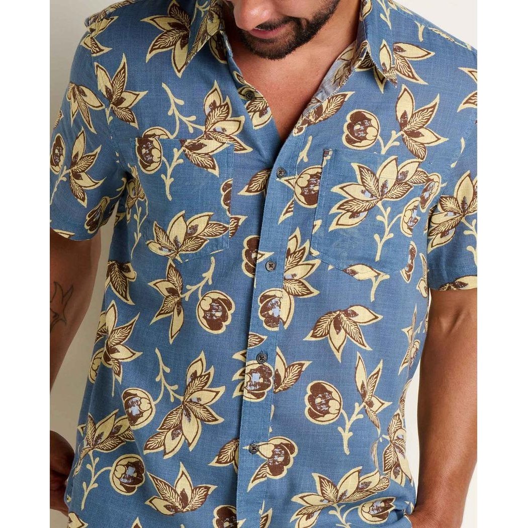 A model wears the Toad & Co Men's Salton Short Sleeve Shirt in Pacific Blue Print, showing the front and a pocket against a plain background.