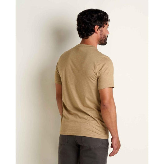 Back view of the Toad & Co Men's Tempo Short Sleeve Pocket Crew in Khaki on a model against a plain wall.