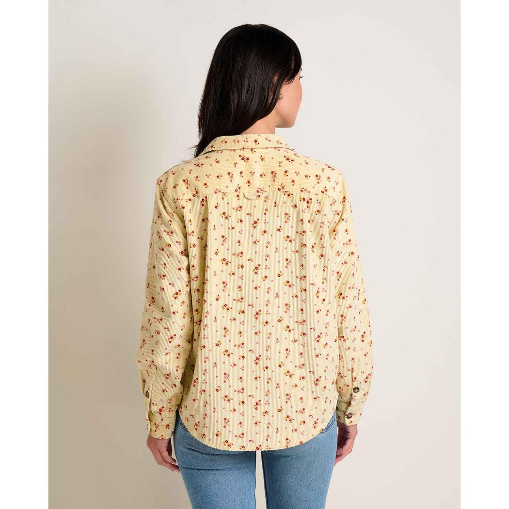 Back view of the Toad & Co Women's Cascadia Long Shirt in Barley Floral Print on a model wearing blue jeans against a plain background.