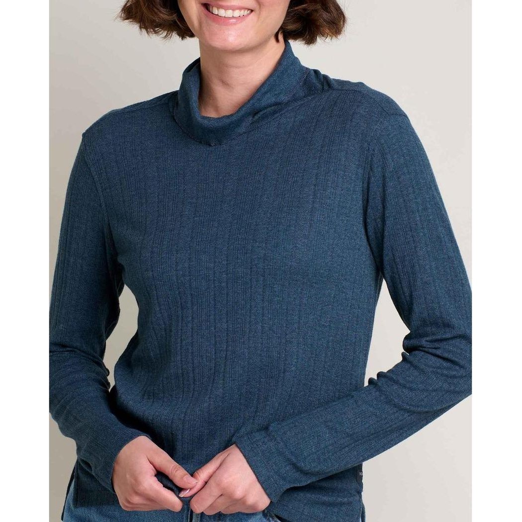 A woman wearing the Toad & Co Women's Foothill Pointelle Long Sleeve T-Neck in Midnight stands against a light background.