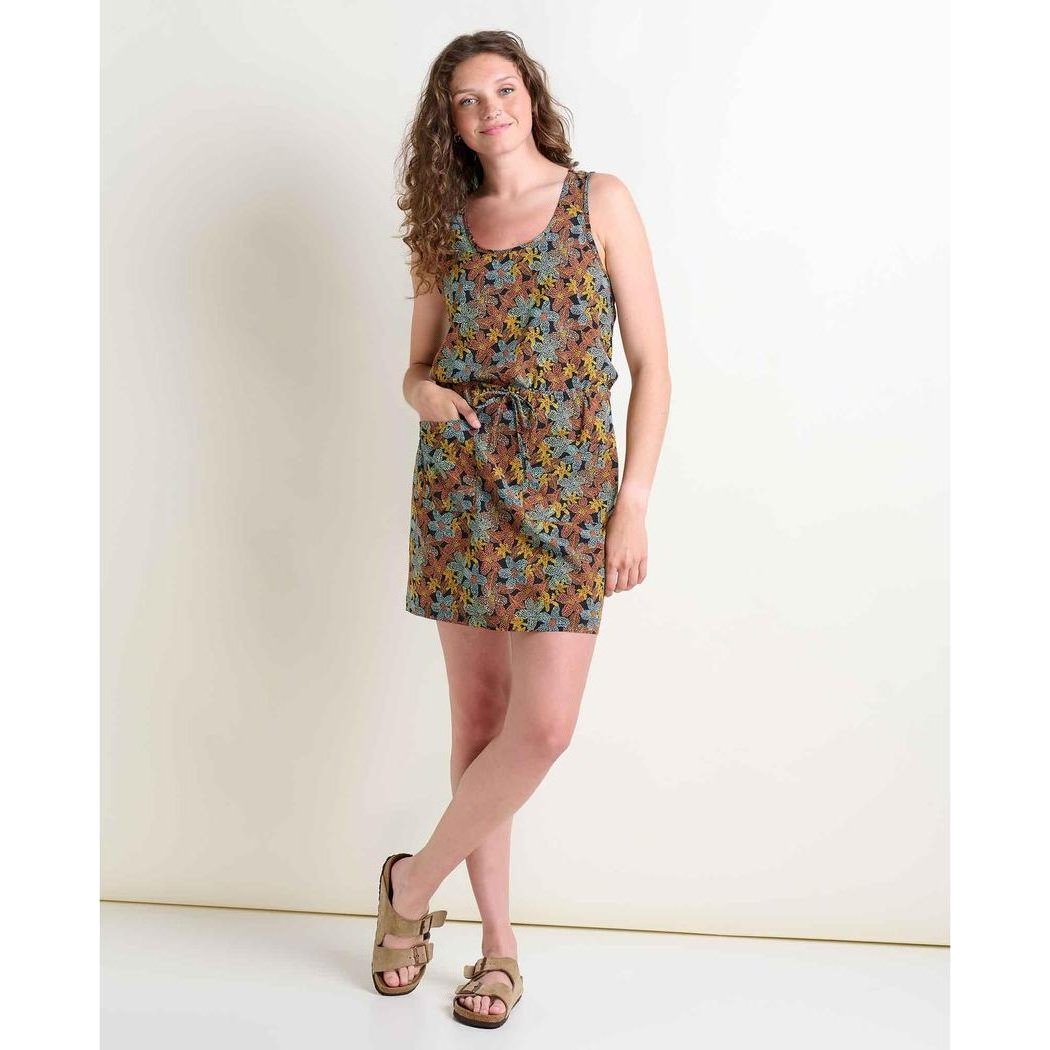 A woman wearing the Toad & Co Women's Livvy Sleeveless Dress in Black Floral Dot Print stands against a plain white background.
