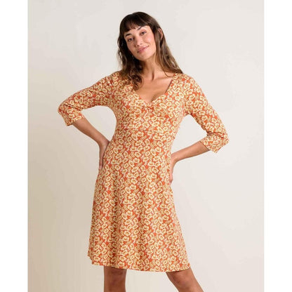 A woman wearing the Toad & Co Women's Rosalinda Dress in GourdIkatPrint poses with her hands on her hips against a plain background.