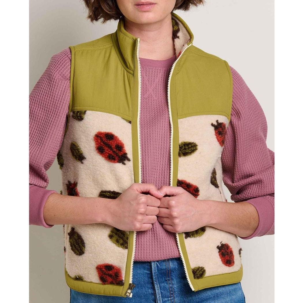 A front view of the Toad & Co Women's Sespe Sherpa Vest in Barley Ladybugs on a model wearing a pink top and blue jeans.