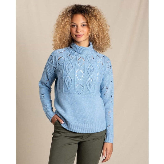 A woman wearing the Toad & Co Women's Tupelo II Cable Sweater in Lake stands against a neutral background.