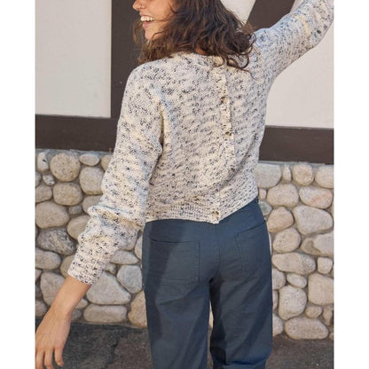 Back view of the Toad & Co Women's Twigtree Button Back Sweater in Natural against a stone wall.
