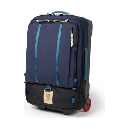 A front view of the Topo Designs Global Travel Bag Roller in Navy/Sahara with red wheels and a black bottom section.