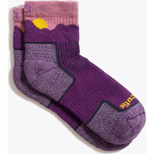 A front view of the Tough Cuties Eve The Original Ladies Light Weight Hiker Quarter Horizon socks in Twilight Blue Horizon with a mountain design and yellow sun on the cuff against a white background.