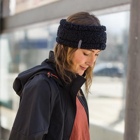 A woman wearing the Turtle Fur Comfort Lush Full Send Wide Band in Black stands outside near a window.