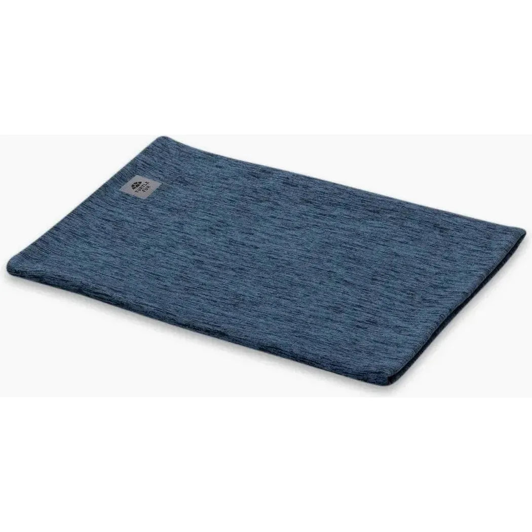A flat lay photo of the Turtle Fur Comfort Stria Pipe Dream in Baltic color, showing the textured fabric and a small logo tag on the upper left corner against a white background.