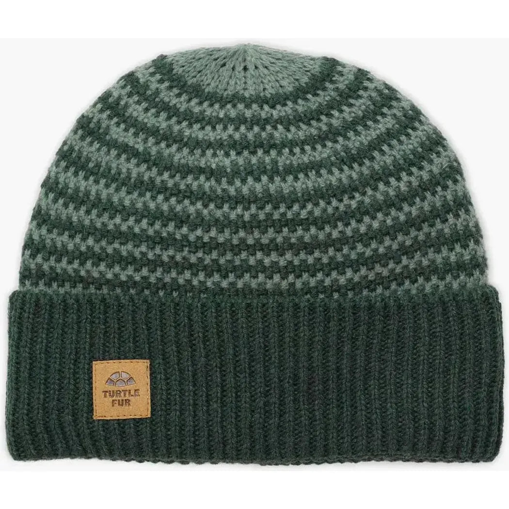 A front view of the Turtle Fur Lambswool Gus hat in Black with a ribbed cuff and a leather tag, against a white background.