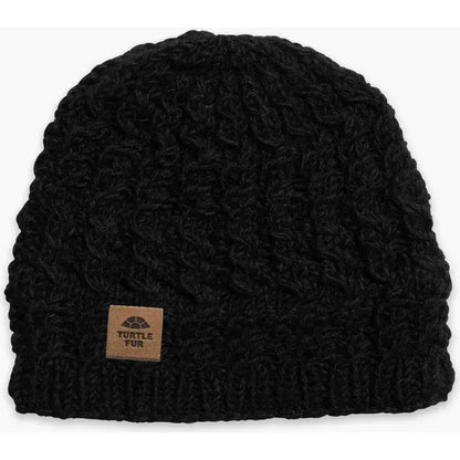 A black Turtle Fur Nepal Handmade Wool Mika beanie with a leather tag, shown from the front against a white background.