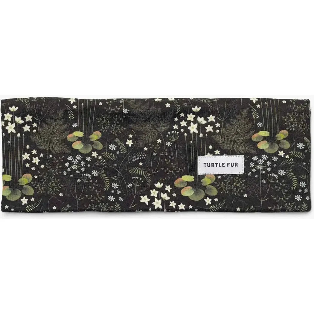 A flat lay photo of the Turtle Fur Women's Comfort Shell adjustable wide bandana in Marsha, showing the floral pattern and the brand label.