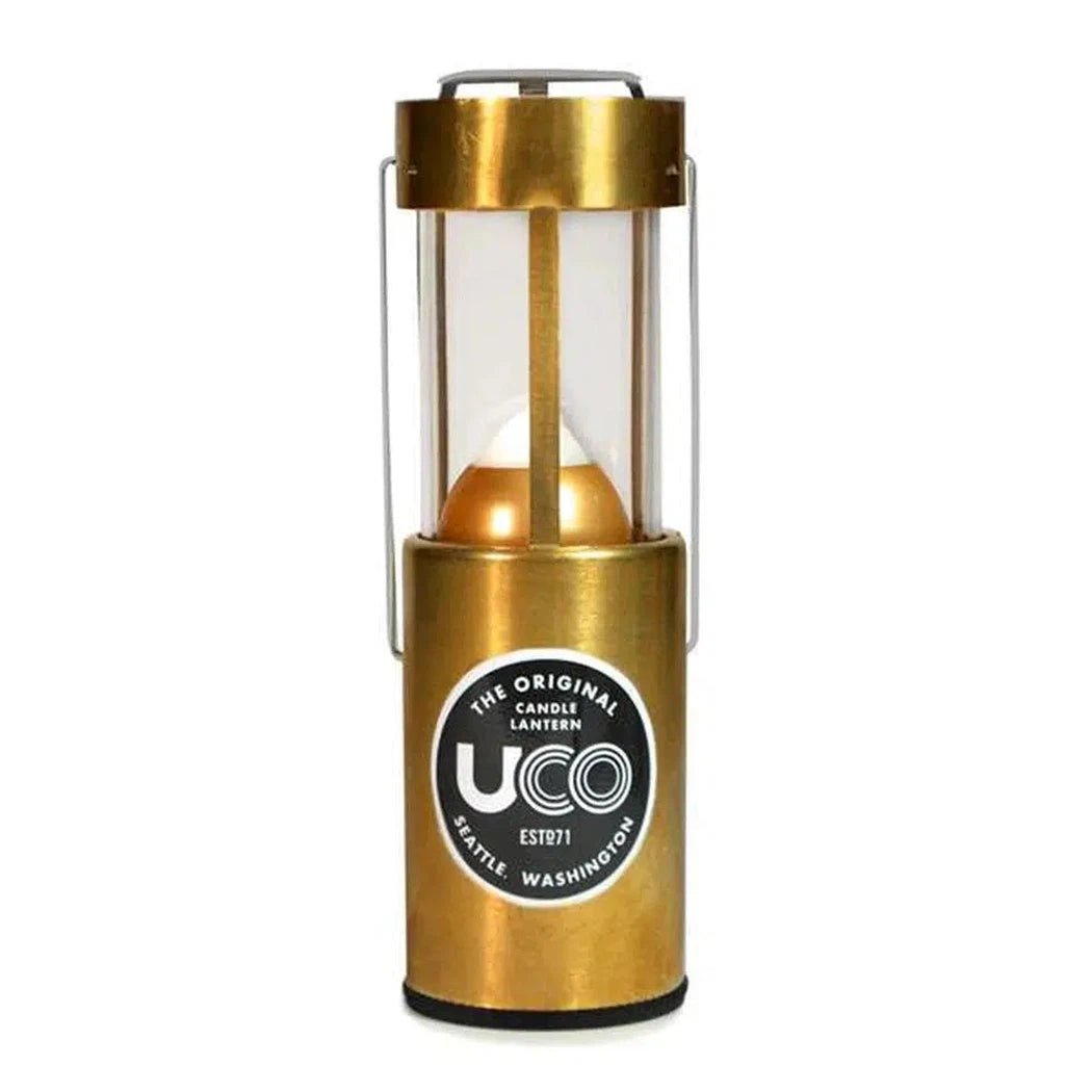 Brass UCO Candle Lantern Standard model with clear glass and metal handle, photographed from front against white background.