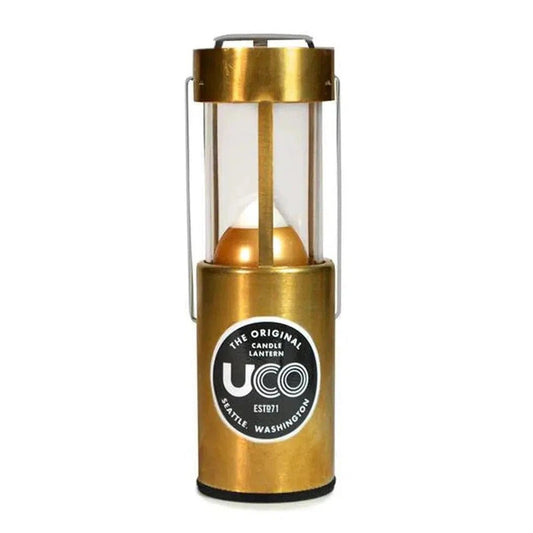 Brass UCO Candle Lantern Standard model with clear glass and metal handle, photographed from front against white background.