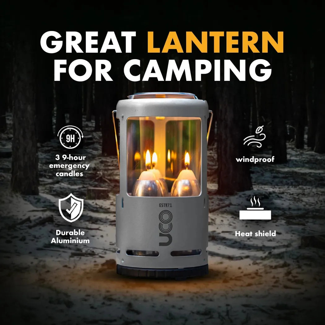A front view of the UCO Candlelier Candle Lantern - Aluminum with its windproof and heat shield features visible against a snowy forest background.