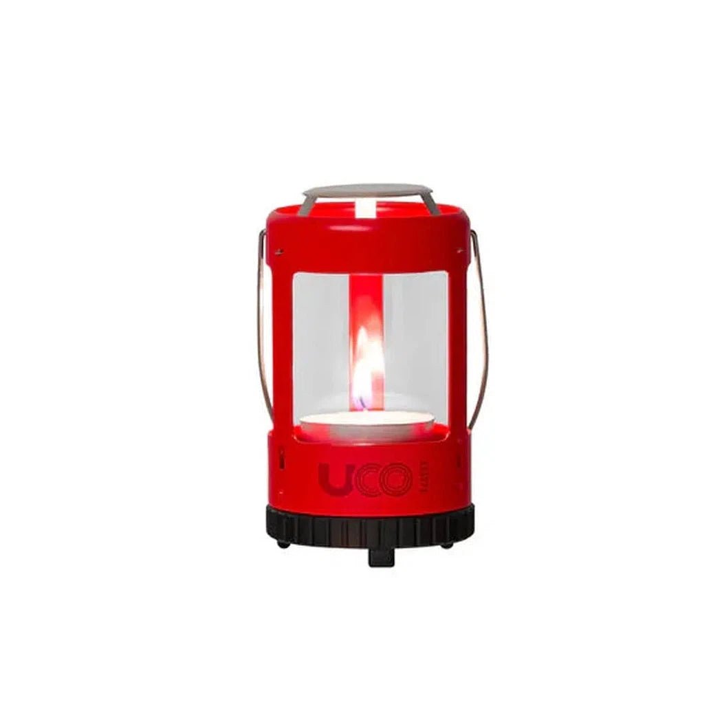 A red UCO Mini Lantern Kit 2.0 with a visible flame inside, shown from a front angle against a white background.
