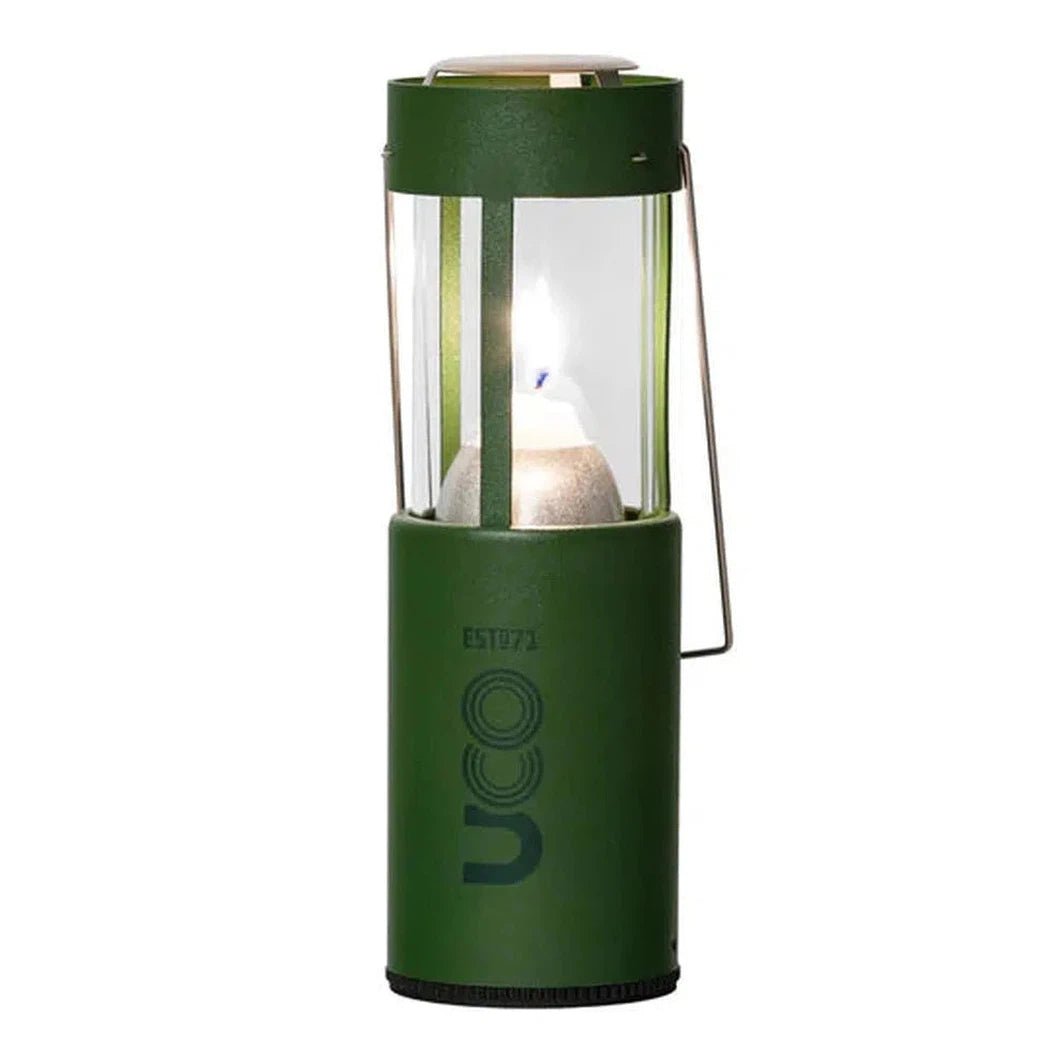 A front view of the UCO Original Candle Lantern in Forest green showing the lit candle inside against a white background.