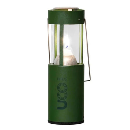 A front view of the UCO Original Candle Lantern in Forest green showing the lit candle inside against a white background.