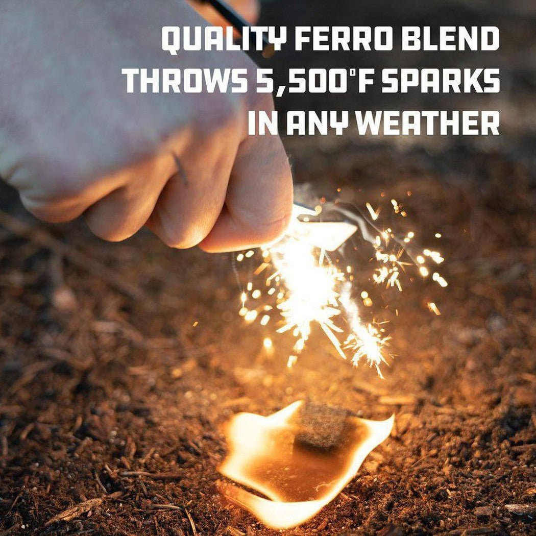 A hand uses the UCO Survival Fire Striker - Ferro Rod to start a fire on dirt ground.